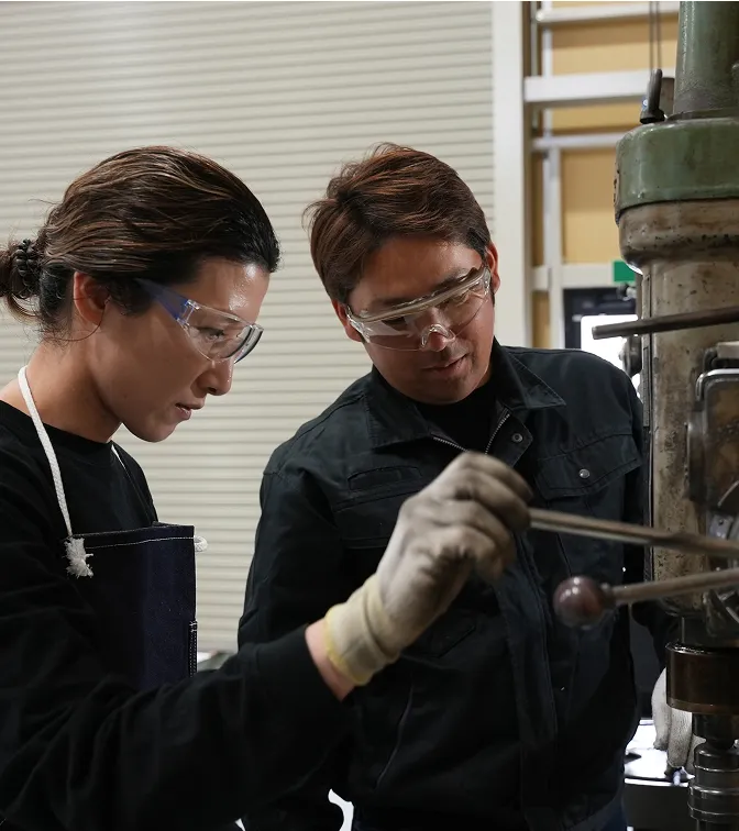 クリップボードを持ち笑顔で作業を確認する女性従業員