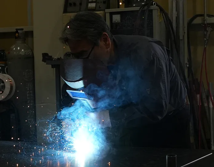 機械を使って金属加工を行う女性職人