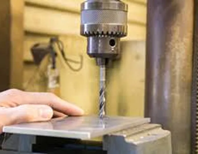 ドリルで金属板に穴を開ける様子