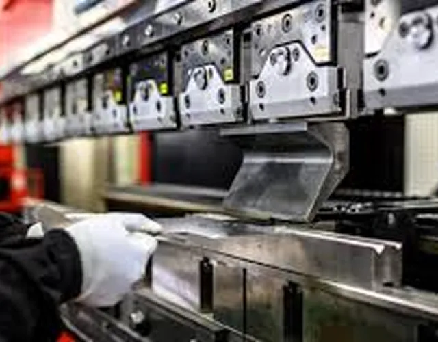 金属部品をプレス機で曲げて組付ける様子