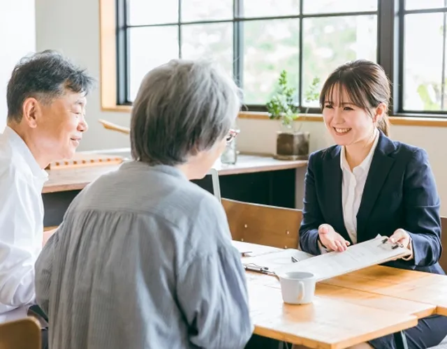 顧客と笑顔で打ち合わせをする担当者